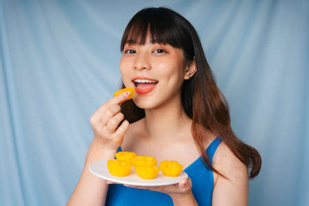 Close up of young asian woman eating sweet golden cake thai desset.