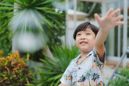 Portrait of asian boy having fum with soap bubble at park.
