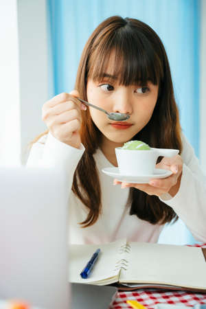 Young asian dark hair woman food reviewer examine thai dessert before writing a review.