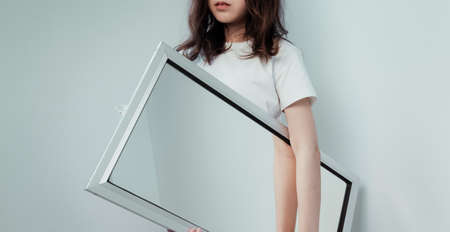 Curly long hair girl carry the mirror with her everywhere.