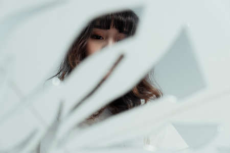 Broken mirror on the floor reflect the lonely curly long hair girl.の写真素材