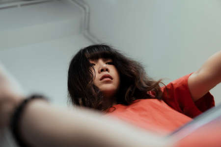 A Thai girl hold the mirror in her hand, her eye sight is empty 'cuase she cannot find the meaning of her life.の写真素材