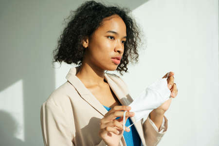 Portrait of african curly hairstyle woman holding a mask for mock up.の写真素材