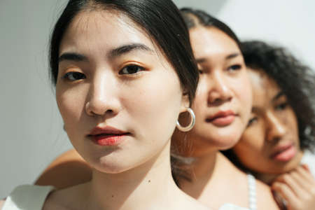 Face portrait of asian and african women on white background.の写真素材