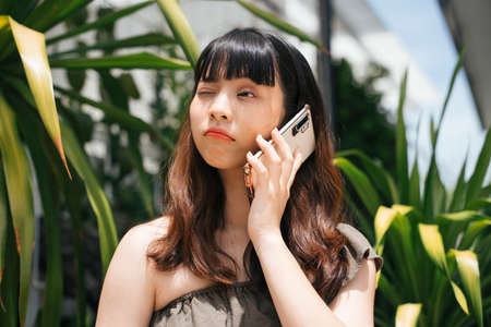 Young asian woman talking on smartphone having problem with boyfriend.の写真素材