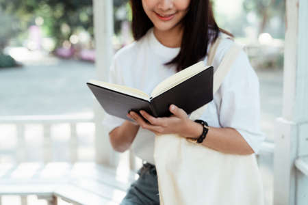 Cropped image of black notebook in cute girl's hands while she read it.の写真素材