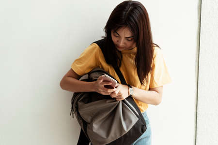 A college girl finding something in her backpack.の写真素材