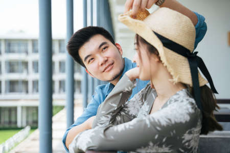 Asian couple traveler standing on hotel balcony looking at the view.の写真素材