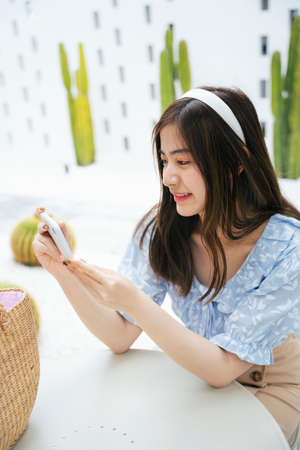 Beautiful asian woman traveler using smartphone outdoors.