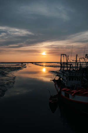 Beautiful sunset view at dawn on sea fisher man boat in Thailand.の写真素材