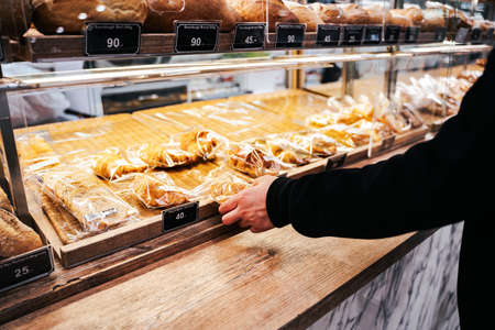 Customer buying fresh baking bread from bakery shef shop in shopping mall.の写真素材
