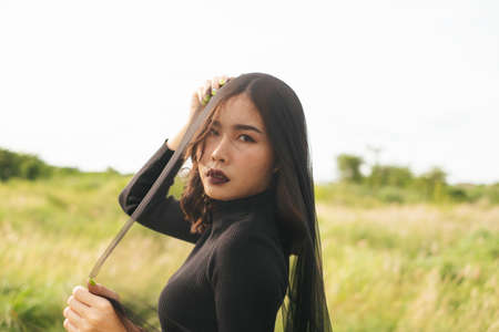 Black bride standing at the field with black vail cover her face.の写真素材