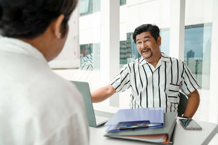 Adult asian businessman working with partner together in office room.の写真素材