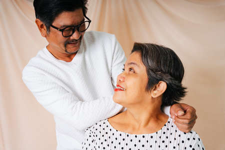 Fashion portrait of cool old elderly senior couple in white shirt. Both looking at each other face.の写真素材