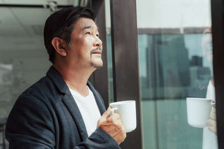Asian business man enjoy cup of coffee in the morning at office.の写真素材