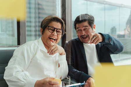 Old elderly senior business people working together in meeting room, pointing at sticky note memo.の写真素材