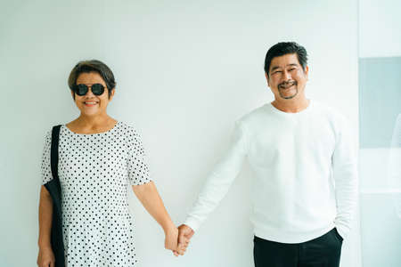 Portrait of cool old elderly senior couple in white shirt holding hands isolate on background.の写真素材