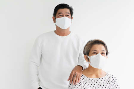 Portrait of cool old elderly senior couple in white shirt wear mask isolate on background.の写真素材