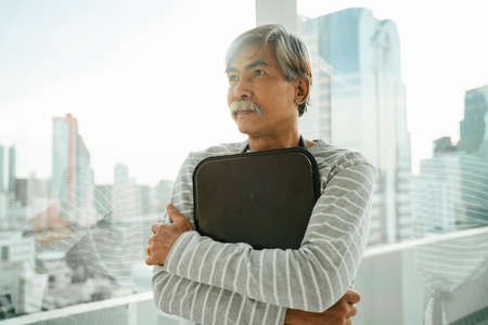 Old elderly senior waiter holding coffee tray.