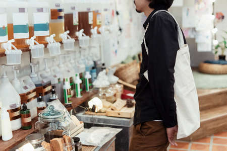 Curly black hair guy with canvas bag looking at the product in the shop.の写真素材