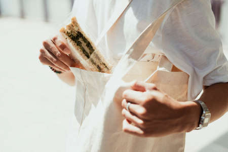 Cropped image of veggie sandwich that the man take it from his white canvas bag.の写真素材