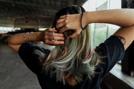 Back short of woman tie her hair to prepare for riding longboard in her weekwnd.の写真素材