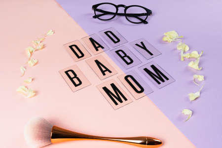 Dad and mom and baby word on pink and purple background with flower in circle shape and family...