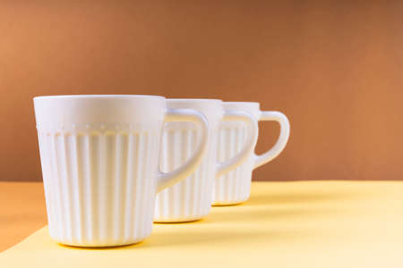 White three cups of different kind of coffee on color background.の写真素材