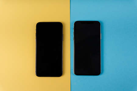 Top view - Two smartphone screen for mock up on yellow and blue background.