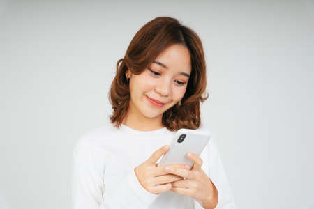 Young asian woman with smartphone isolate on white background.の写真素材