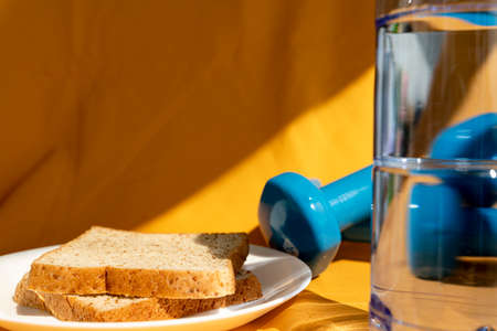 Two piece of bread slice and fresh water for breakfast. Healthy meal for muscle builder.の写真素材