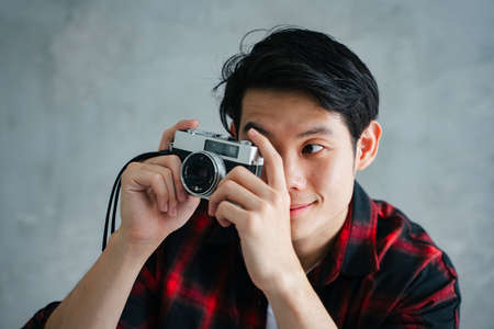 Portrait of young asian photographer hold vintage film camera.