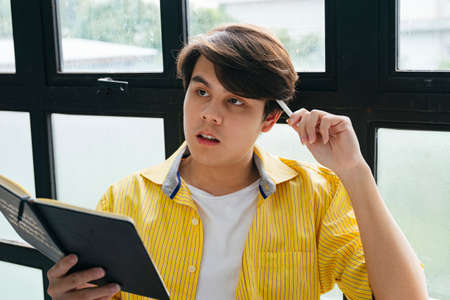 Asian young man thinking about idea for new business.の写真素材
