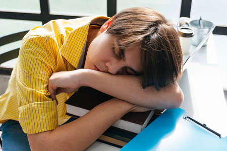 Asian young man fall asleep on books after study.の写真素材