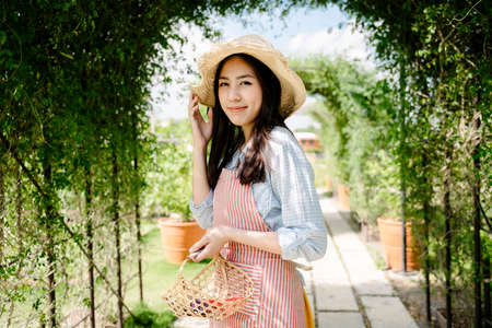 Portrait of asian farmer woman wear hat hold vegetables basket.の写真素材