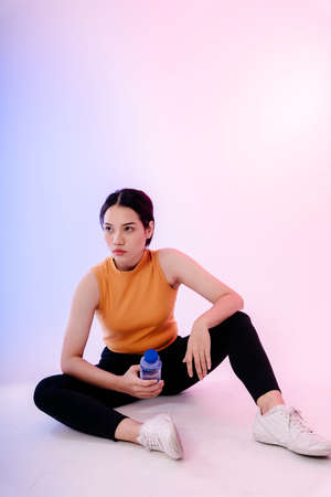 Asian healthy woman take a rest after exercise in gym.