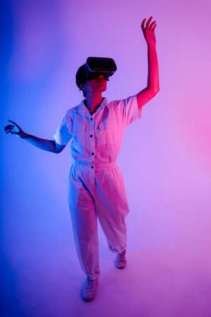Portrait of young asian woman using VR headset goggles to play game and video.