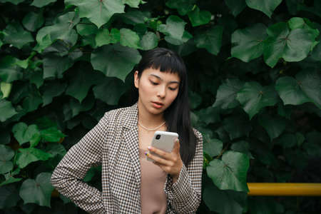 Asian business woman in formal shirt using smartphone on nature background.の写真素材