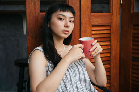 Beautiful asian woman enjoy cup of hot coffee in the morning.