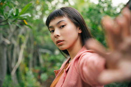 Asian business woman in pink formal shirt over nature background.