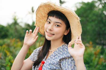 Portrait of cheerful traveler asian woman with straw hat in nature.の写真素材