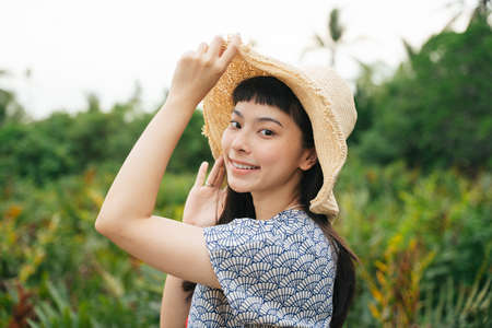 Portrait of cheerful traveler asian woman with straw hat in nature.の写真素材