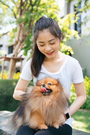 Beautiful asian woman and her lovely pomeranian spitz dog.の写真素材