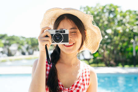 Portrait of beautiful asian woman wear hat taking photo with camera.