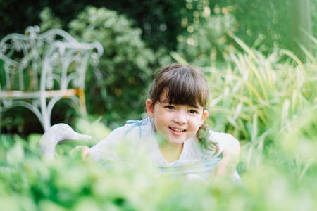 Cute little girl having fun at garden backyard in summer.の写真素材