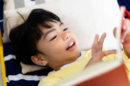 Little boy playing mobile game on smartphone in bedroom.の写真素材