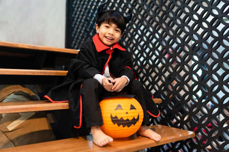 Little boy in halloween costume and pumpkin balloon in the party.の写真素材