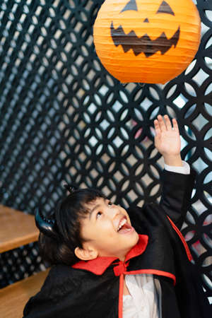 Little boy in halloween costume and pumpkin balloon in the party.の写真素材