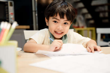 Little boy doing homework with happiness at home.の写真素材