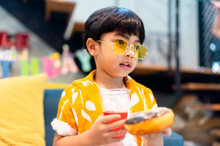 Little boy in yellow jacket looking for food in the party.の写真素材